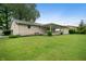 This backyard features a well-manicured lawn, mature trees, and landscaping, creating a serene outdoor space at 7482 W Us Highway 40, Indianapolis, IN 46229