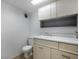 Bathroom featuring a toilet, sink, vanity, tile floor, and cabinet storage at 7482 W Us Highway 40, Indianapolis, IN 46229
