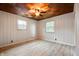 This bedroom features two windows, light wood floors, and a unique basket-weave wood ceiling with ceiling fan at 7482 W Us Highway 40, Indianapolis, IN 46229