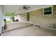 The covered patio has concrete flooring, exposed aggregate siding, and a ceiling fan for outdoor enjoyment at 7482 W Us Highway 40, Indianapolis, IN 46229
