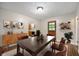 Inviting dining room with wood table, ample seating, hardwood floors, and a view into the updated kitchen at 7482 W Us Highway 40, Indianapolis, IN 46229