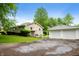 View of home exterior featuring a two-car detached garage and green lawn at 7482 W Us Highway 40, Indianapolis, IN 46229