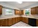 Kitchen featuring wood cabinets, laminate countertops, and stainless steel sink at 7482 W Us Highway 40, Indianapolis, IN 46229