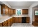 Kitchen featuring wood cabinets, laminate countertops, and modern appliances at 7482 W Us Highway 40, Indianapolis, IN 46229