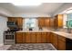Efficient kitchen with stainless steel appliances, wood cabinets, light countertops, and a neutral color scheme at 7482 W Us Highway 40, Indianapolis, IN 46229