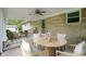 Back patio featuring stone wall, ceiling fan, and dining set at 7482 W Us Highway 40, Indianapolis, IN 46229