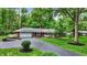 Classic single-level brick home with a spacious driveway, manicured lawn, and lush surrounding trees at 8641 Cholla Rd, Indianapolis, IN 46240
