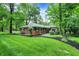 Charming single-story brick home featuring lush landscaping, mature trees and an expansive green lawn at 8641 Cholla Rd, Indianapolis, IN 46240