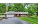 Charming brick home featuring a well-manicured lawn, mature trees, and an inviting front porch at 8641 Cholla Rd, Indianapolis, IN 46240