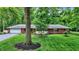 Inviting brick home with lush lawn, landscaped flowerbeds, mature trees and a cozy front porch at 8641 Cholla Rd, Indianapolis, IN 46240