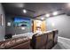 Basement media room with large screen, comfortable seating, and open doorway to recreation area at 8802 W 86Th St, Indianapolis, IN 46278