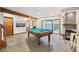Spacious game room features a pool table, a stone fireplace, and a view of the indoor pool area at 8802 W 86Th St, Indianapolis, IN 46278