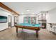 Spacious game room features a pool table, a stone fireplace, and a view of the indoor pool area at 8802 W 86Th St, Indianapolis, IN 46278