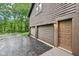 Attached two-car garage with brown wood siding and door, as well as an entrance door at 8802 W 86Th St, Indianapolis, IN 46278