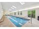 Indoor pool area with natural light, arched windows, and deck access at 8802 W 86Th St, Indianapolis, IN 46278
