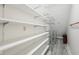 Walk-in closet with built-in shelving offering ample storage space, suitable for organizing clothes and accessories at 8802 W 86Th St, Indianapolis, IN 46278