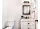 Bathroom featuring a modern vanity, toilet, mirror, and fixtures with clean lines and neutral tones at 918 S State Ave, Indianapolis, IN 46203