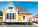 Charming home with a bright yellow front door, wooden shutters, and welcoming front porch at 918 S State Ave, Indianapolis, IN 46203