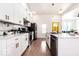 Contemporary kitchen featuring modern appliances, white cabinets, and marble backsplash at 918 S State Ave, Indianapolis, IN 46203