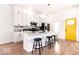 Well-lit kitchen with an island, modern fixtures, and a bright yellow door adding a pop of color at 918 S State Ave, Indianapolis, IN 46203