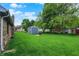 Lush backyard with mature trees, a storage shed, well-maintained lawn and brick house at 926 Brookside Ln, Plainfield, IN 46168