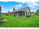Spacious backyard featuring a brick home with an enclosed sunroom and a well-maintained lawn at 926 Brookside Ln, Plainfield, IN 46168