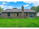 Exterior view of brick home, showing the backyard and chimney against a vibrant blue sky at 926 Brookside Ln, Plainfield, IN 46168