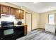 Galley kitchen featuring black appliances, light-colored vinyl flooring, and wood cabinets at 926 Brookside Ln, Plainfield, IN 46168