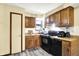 Galley kitchen featuring black appliances, light-colored vinyl flooring, and wood cabinets at 926 Brookside Ln, Plainfield, IN 46168