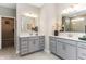 Elegant bathroom features dual vanities with gray cabinetry, quartz countertops, and modern fixtures at 9352 Corbett Dr, McCordsville, IN 46055
