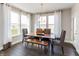 Dining room with a wooden table, gray upholstered chairs, a bench, and large windows providing natural light at 9352 Corbett Dr, McCordsville, IN 46055