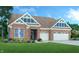 Charming brick home featuring a two-car garage, well-kept lawn and architectural roof with stylish gable windows at 9352 Corbett Dr, McCordsville, IN 46055