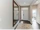 Bright hallway featuring hardwood floors, a large mirror, and a view of the front door at 9352 Corbett Dr, McCordsville, IN 46055