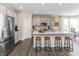 Well-lit kitchen with gray cabinets, stainless steel appliances, a white countertop island with stools, and wood flooring at 9352 Corbett Dr, McCordsville, IN 46055
