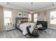 Serene main bedroom features a tray ceiling, plush bed, elegant lighting, and comfortable seating area at 9352 Corbett Dr, McCordsville, IN 46055