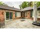 Charming back patio featuring stone pavers, a brick exterior, and multiple access doors to the home at 9550 Copley Dr, Indianapolis, IN 46260