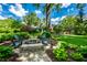 A stunning backyard with a stone patio, firepit, Adirondack chairs, bench seating, and verdant landscaping at 9550 Copley Dr, Indianapolis, IN 46260