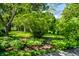 Picturesque backyard garden with lush plantings, a stone pathway, and mature shade trees at 9550 Copley Dr, Indianapolis, IN 46260