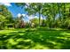 A wide green lawn in a lush backyard is framed by mature trees and meticulous landscaping around the perimeter at 9550 Copley Dr, Indianapolis, IN 46260