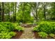 An inviting stone patio with beautiful plants and seating, with a firepit for outdoor relaxation in a lush, green setting at 9550 Copley Dr, Indianapolis, IN 46260