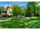 Expansive backyard lawn featuring mature trees, manicured landscaping, and a tranquil outdoor seating area at 9550 Copley Dr, Indianapolis, IN 46260