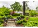 An inviting backyard featuring an outdoor stone patio, chairs, and fire pit, all surrounded by lush landscaping at 9550 Copley Dr, Indianapolis, IN 46260