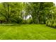 An expansive lush green backyard, featuring mature trees and manicured landscaping, providing a serene, private outdoor space at 9550 Copley Dr, Indianapolis, IN 46260