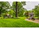 Scenic backyard view with lush lawn, mature trees, manicured landscaping, and cozy seating areas at 9550 Copley Dr, Indianapolis, IN 46260