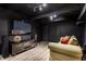 Cozy finished basement with TV, laminate floors, couch and dark walls and ceiling at 9550 Copley Dr, Indianapolis, IN 46260