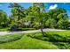 Long driveway leads to a brick home surrounded by mature trees and manicured landscaping at 9550 Copley Dr, Indianapolis, IN 46260