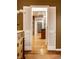 Hallway view through open louvered doors, showing hardwood floors and neutral walls at 9550 Copley Dr, Indianapolis, IN 46260