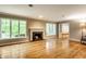 Bright living room with hardwood floors, a fireplace, and large windows with backyard views at 9550 Copley Dr, Indianapolis, IN 46260