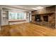 Cozy living room with hardwood floors, a brick fireplace, and built-in shelving at 9550 Copley Dr, Indianapolis, IN 46260