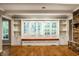 Open living room featuring custom built-in window seat, shelving, and brick fireplace at 9550 Copley Dr, Indianapolis, IN 46260